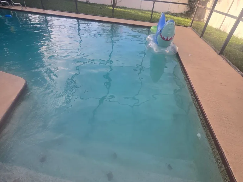 The same screened-in pool with clear blue water after recovery